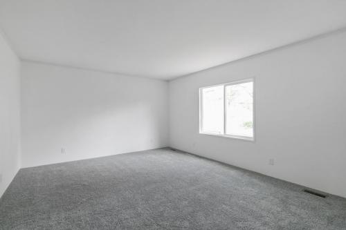 Empty room with gray carpet and white walls.